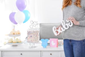 Baby shower with woman holding a sign saying baby