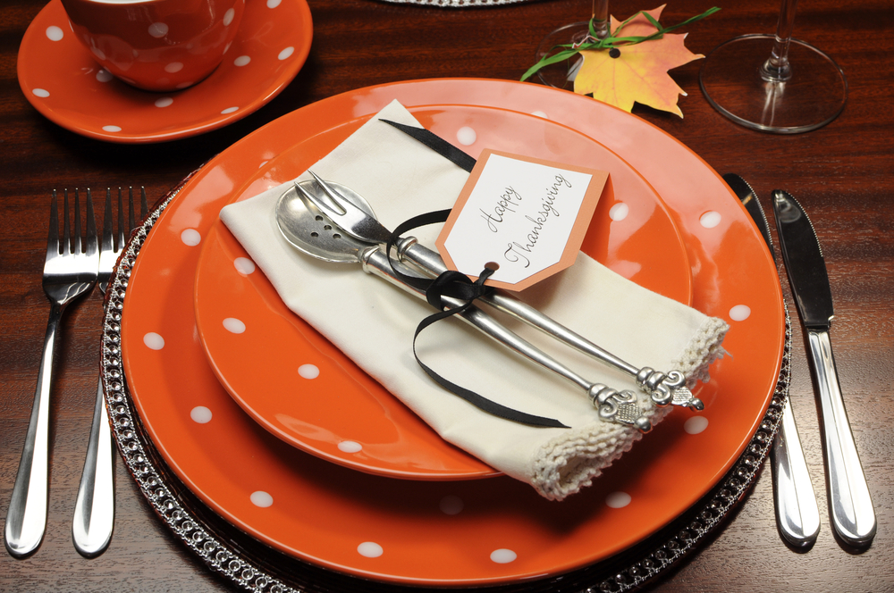 Red with white dot china and flatware on set table