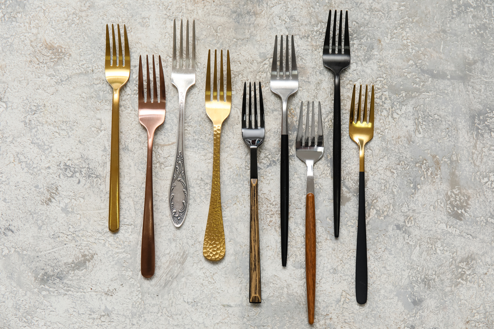 silver, gold, copper, and black forks all lined up