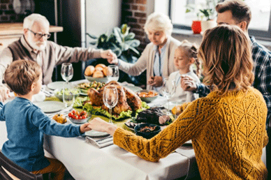 family holding hands in prayer over the dinner table